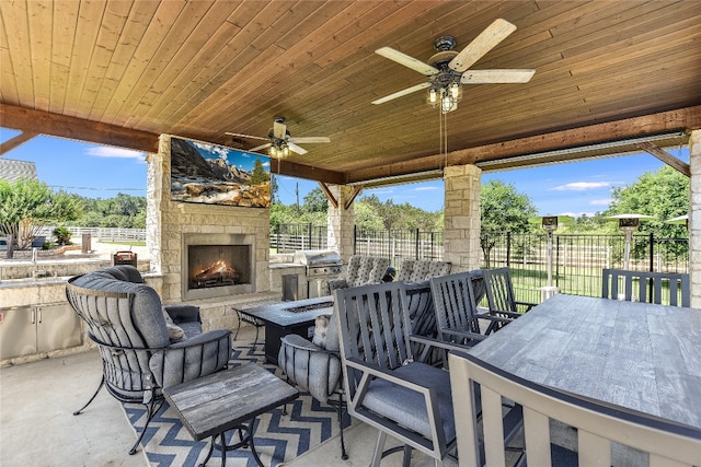 view of patio / terrace with an outdoor stone fireplace and ceiling fan