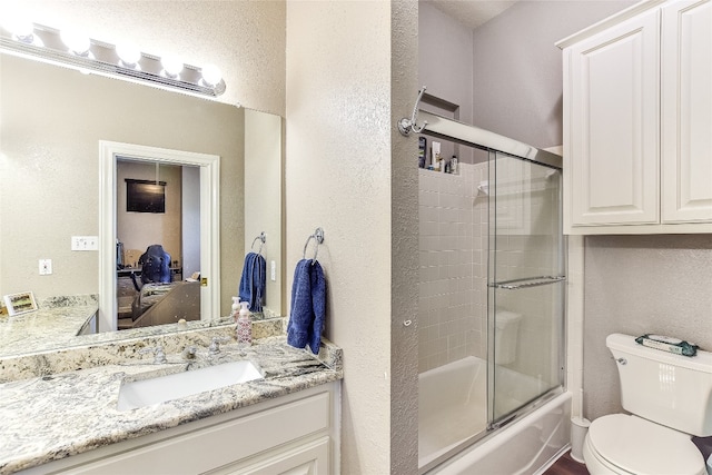 full bathroom with toilet, vanity, and enclosed tub / shower combo