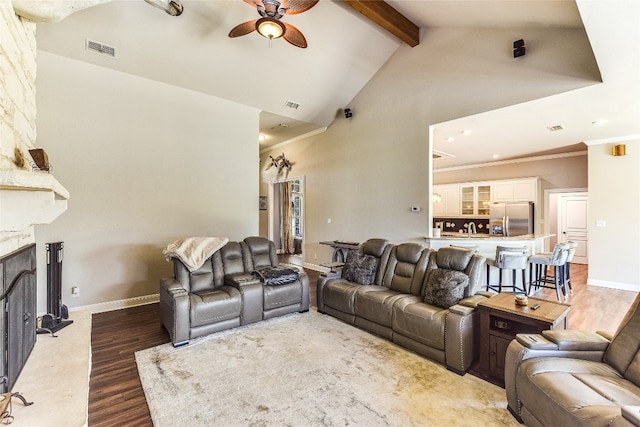 living room with beamed ceiling, ceiling fan, high vaulted ceiling, dark hardwood / wood-style floors, and a fireplace