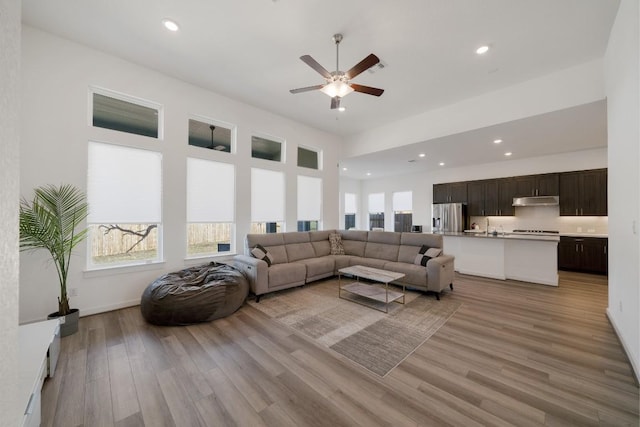 living room featuring ceiling fan and light wood-type flooring