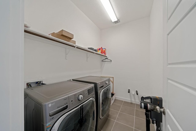 laundry room with light tile patterned floors and separate washer and dryer