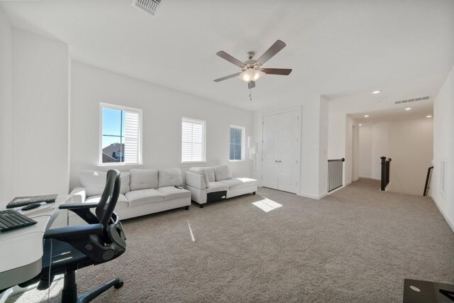 carpeted office space with ceiling fan