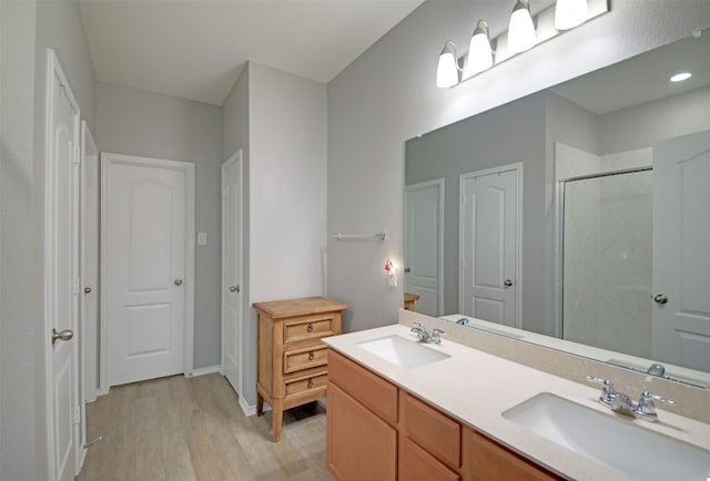 bathroom with dual bowl vanity and wood-type flooring