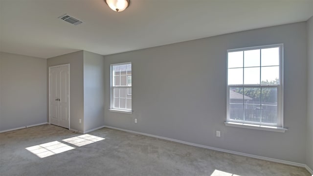 carpeted empty room featuring plenty of natural light