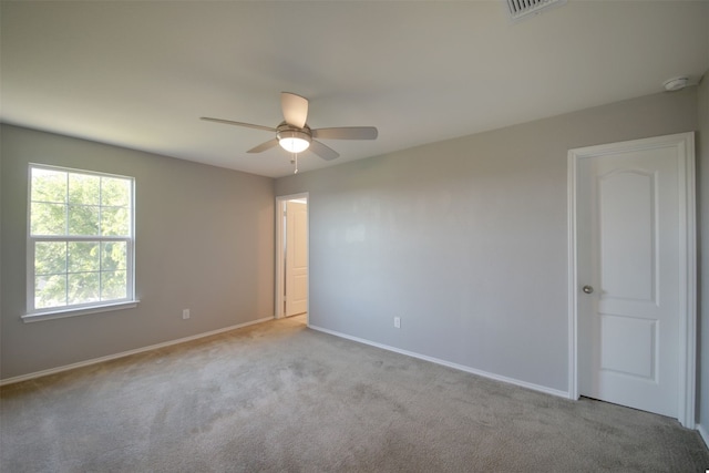 carpeted spare room featuring ceiling fan