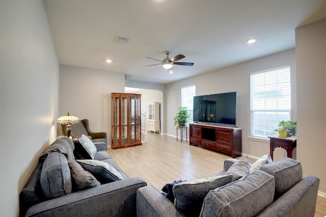 living room with light hardwood / wood-style floors and ceiling fan