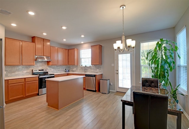 kitchen with hanging light fixtures, stainless steel appliances, a healthy amount of sunlight, and light wood-type flooring