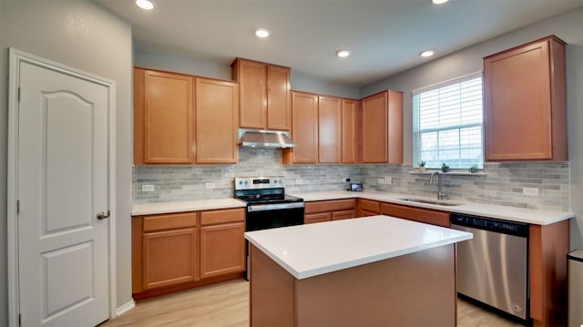 kitchen featuring sink, decorative backsplash, a kitchen island, and appliances with stainless steel finishes