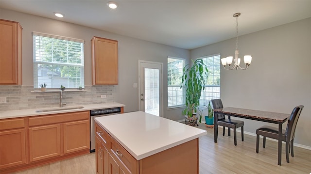 kitchen with sink, dishwasher, a center island, decorative backsplash, and decorative light fixtures