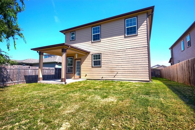 back of house with a patio and a yard