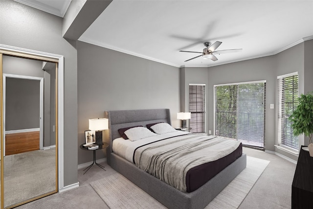 carpeted bedroom featuring ceiling fan and crown molding