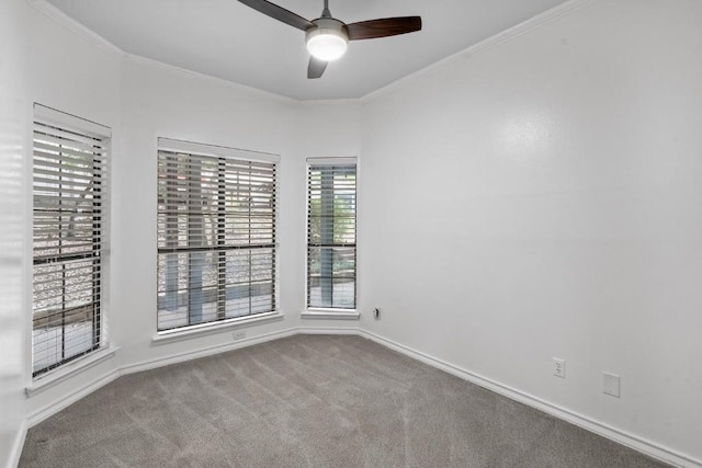 carpeted empty room with ceiling fan, crown molding, and a wealth of natural light