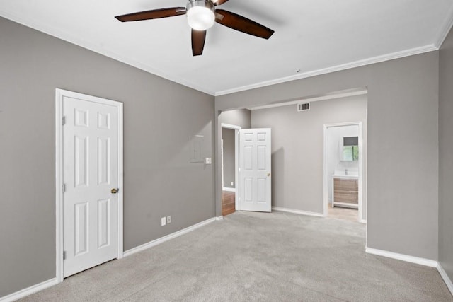 carpeted spare room with ceiling fan and ornamental molding