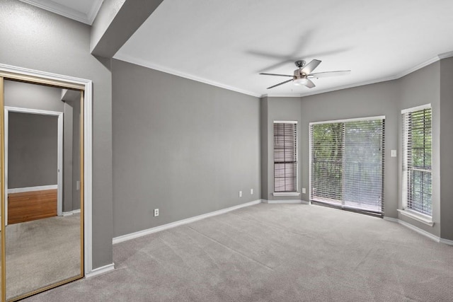 carpeted spare room featuring ceiling fan and crown molding