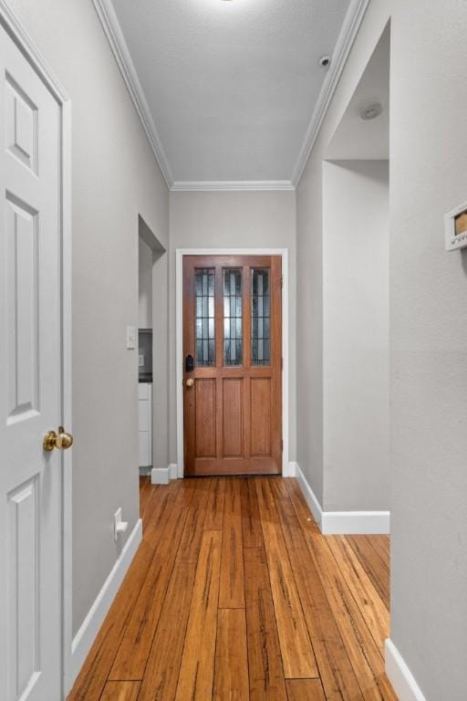 interior space featuring light wood-type flooring and ornamental molding