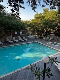 view of pool with a deck and a hot tub