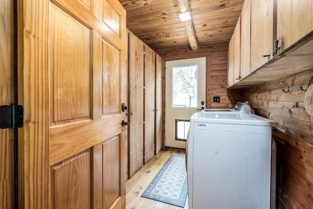 washroom featuring cabinets, light wood-type flooring, and wooden walls