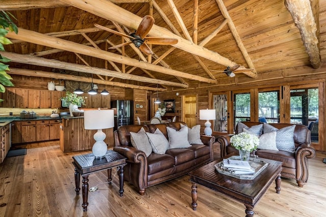 living room featuring beam ceiling, wooden walls, wooden ceiling, and light wood-type flooring