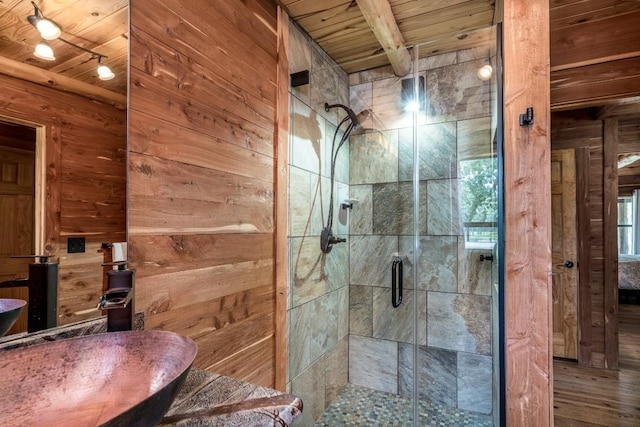 bathroom with hardwood / wood-style floors, wood ceiling, sink, and wooden walls