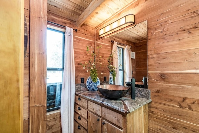 bathroom featuring beam ceiling, wooden walls, vanity, and wood ceiling