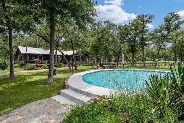 view of pool with a yard