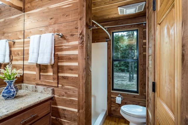 bathroom featuring hardwood / wood-style flooring, vanity, and wooden walls