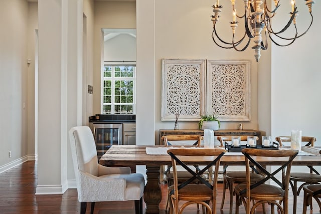 dining room with dark hardwood / wood-style floors, beverage cooler, and an inviting chandelier