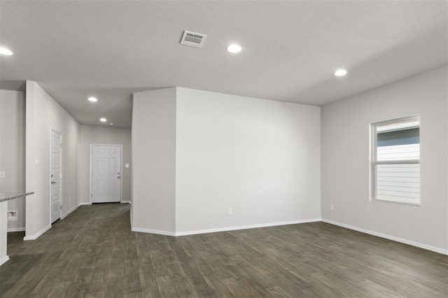 unfurnished room with dark wood-type flooring