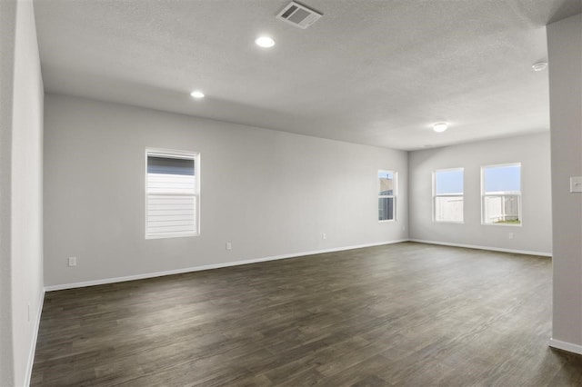 empty room featuring dark hardwood / wood-style flooring and a textured ceiling