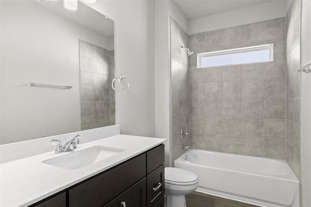 full bathroom with toilet, tiled shower / bath combo, vanity, and hardwood / wood-style flooring