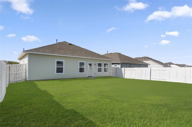 rear view of property featuring a lawn