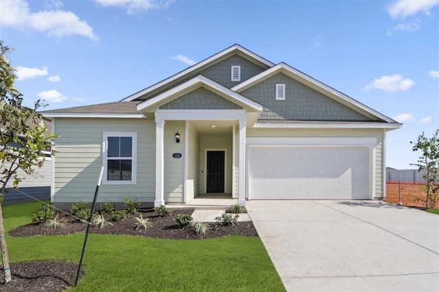 view of front of property featuring concrete driveway, a garage, and a front lawn