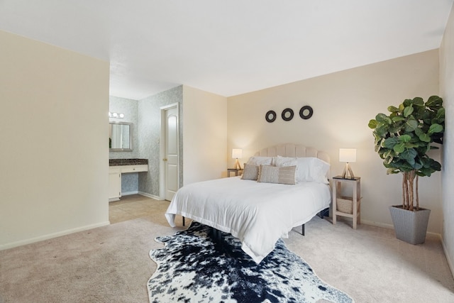 bedroom featuring light colored carpet and ensuite bath