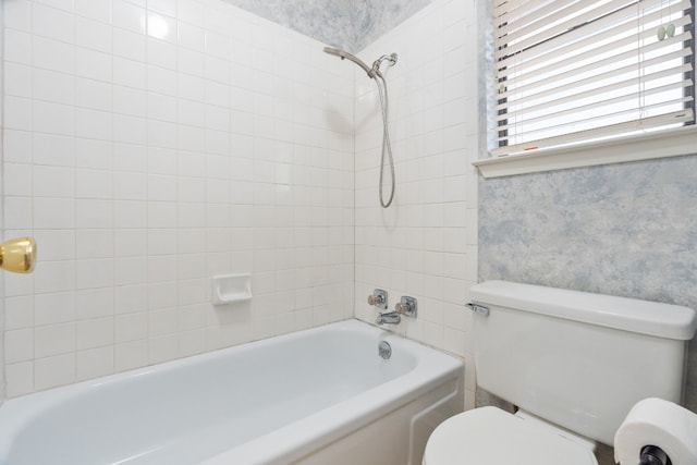 bathroom featuring toilet and tiled shower / bath combo