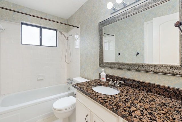 full bathroom with tiled shower / bath combo, toilet, tile patterned floors, and vanity