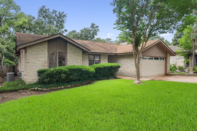 single story home with a front yard, central AC, and a garage