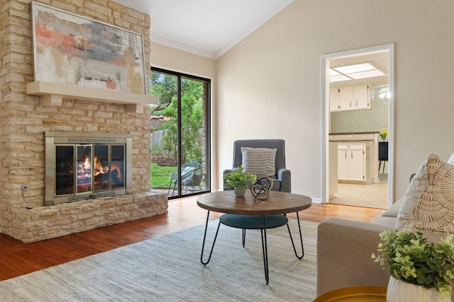 sitting room with wood-type flooring, crown molding, and a fireplace