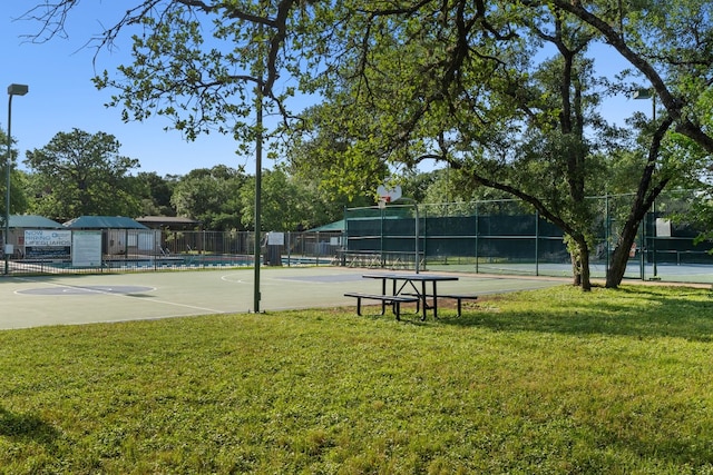 view of community with a yard and basketball hoop