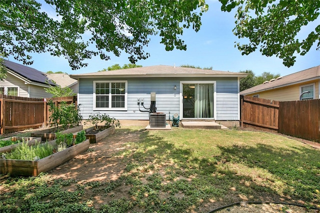 back of house featuring a yard and central air condition unit