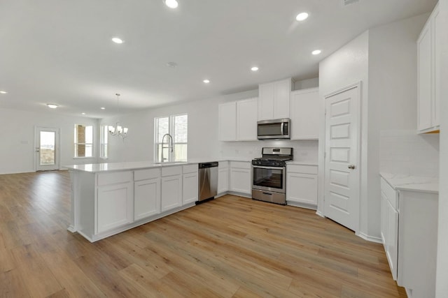 kitchen with kitchen peninsula, stainless steel appliances, and a healthy amount of sunlight