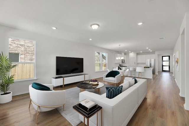 living room featuring light wood-type flooring and an inviting chandelier