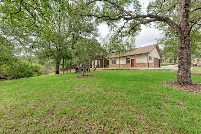 101 Lost Buck, Horseshoe Bay, TX 78657 - view of green lawn featuring a garage and driveway
