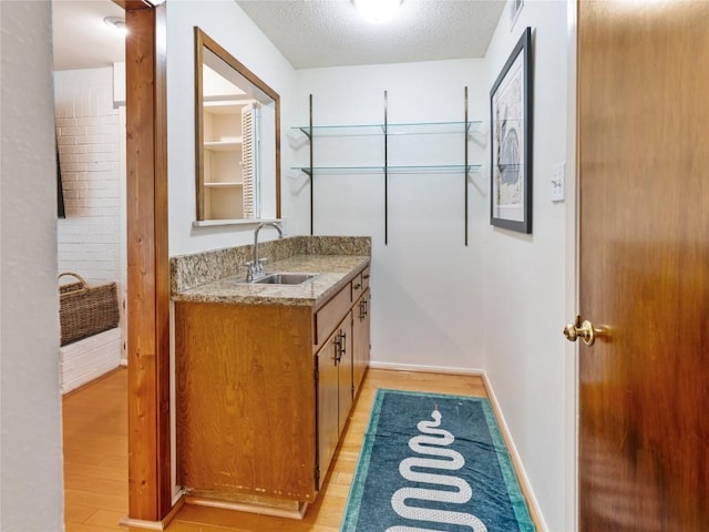 bathroom with hardwood / wood-style flooring, vanity, and a textured ceiling