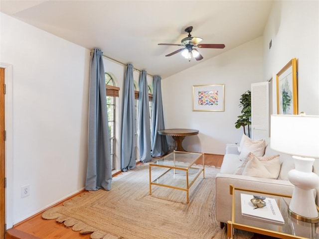 living room with ceiling fan, wood-type flooring, and vaulted ceiling