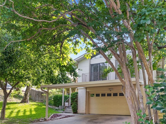 view of front facade with a balcony, a front yard, and a garage