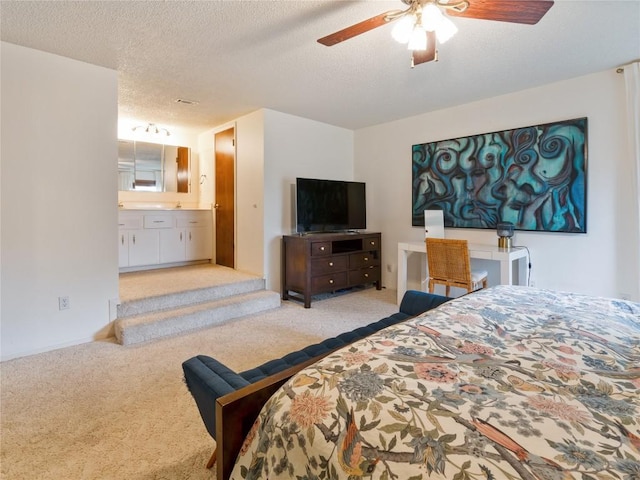 carpeted bedroom featuring a textured ceiling, ceiling fan, and connected bathroom