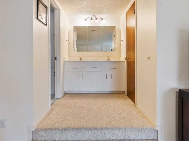 hallway featuring a textured ceiling and sink