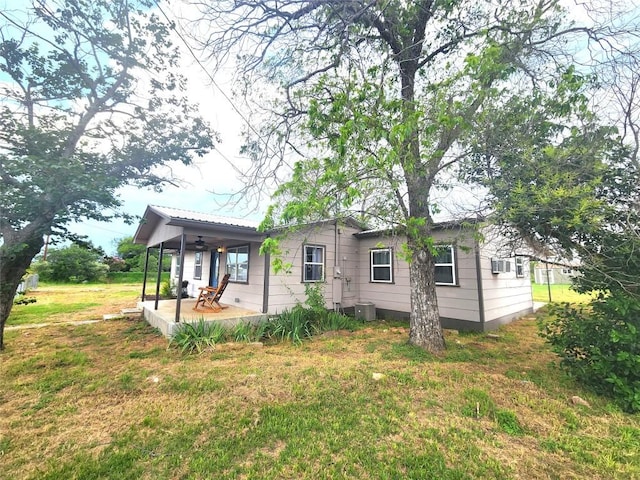 exterior space with central AC, a porch, and a lawn