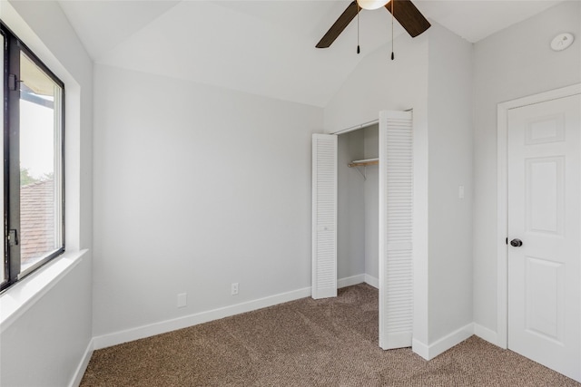 unfurnished bedroom featuring multiple windows, a closet, ceiling fan, and lofted ceiling