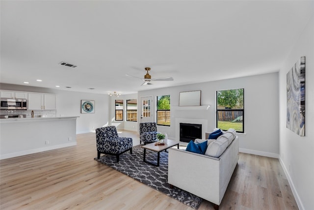 living room featuring ceiling fan and light hardwood / wood-style flooring